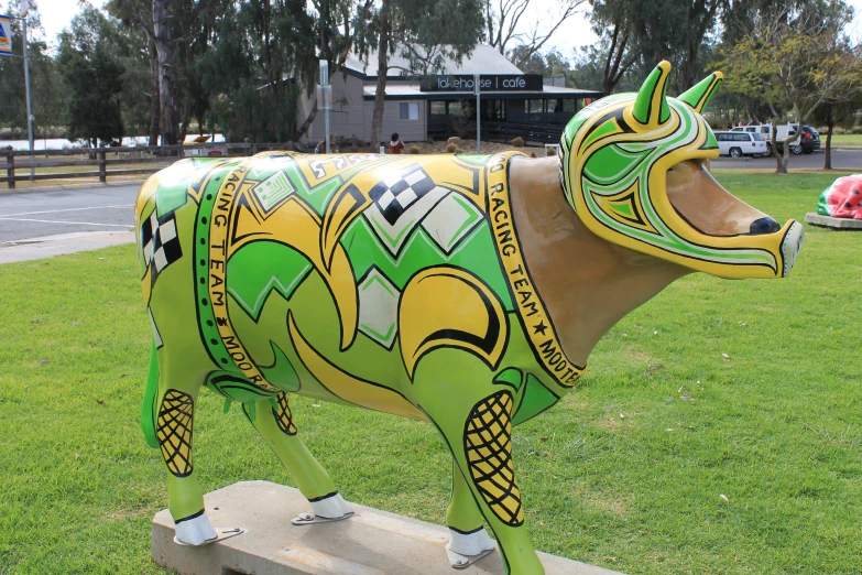 a cow is in the middle of the field with green and yellow designs