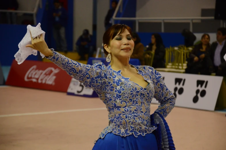 a woman in blue clothes holding a white napkin