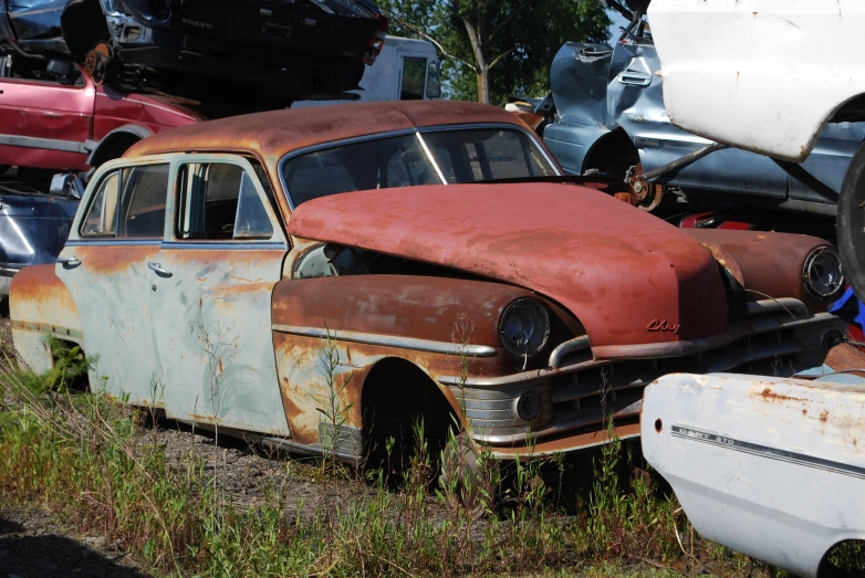 a group of junked cars, some without doors
