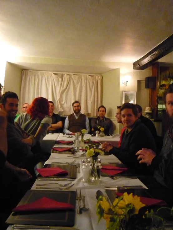 people sitting at tables with place settings in a restaurant