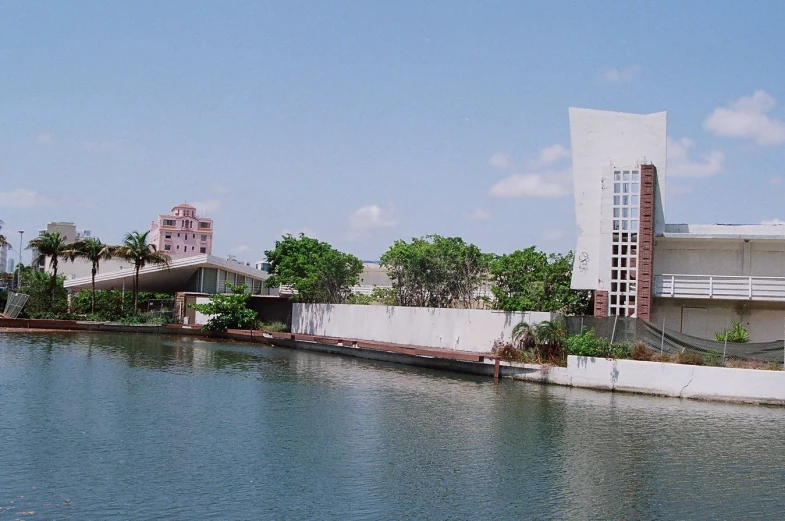 a body of water sitting next to trees and buildings