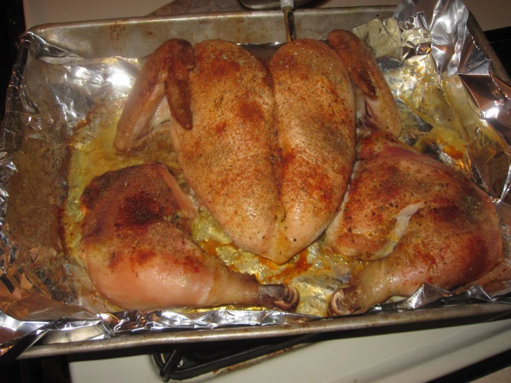 a pan covered in chicken sitting on top of a stove