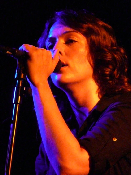 a woman that is holding a microphone up in the air