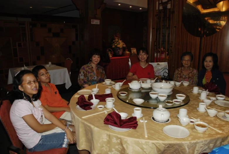 women at a table with white and red plates