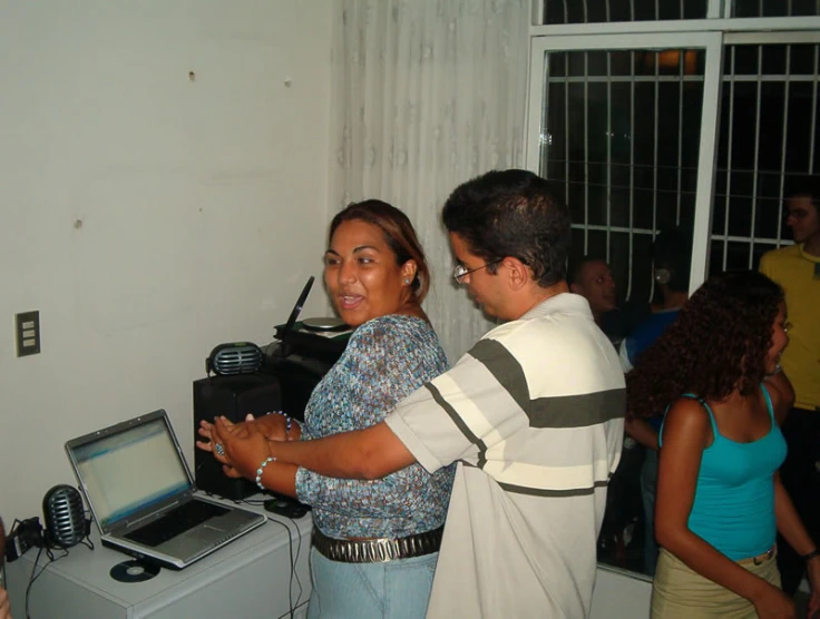 two people are standing next to a small electronic box