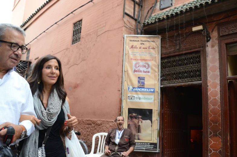 a woman talking to an old man on the street