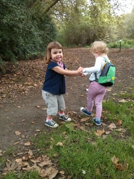 two children playing tug of war on the park path