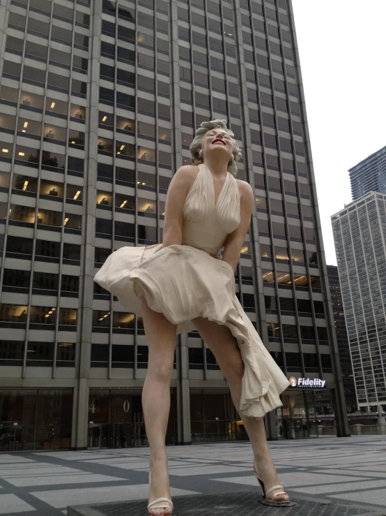 a statue of a woman in a dress is standing on the corner