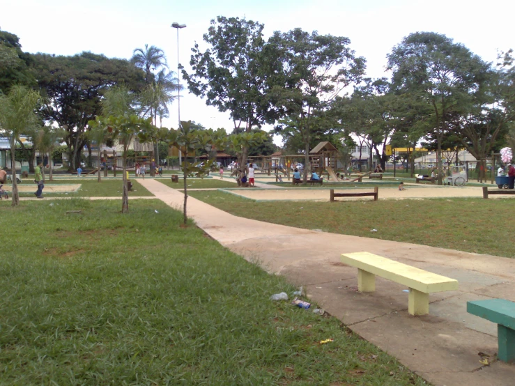 a park with a walkway and a row of benches