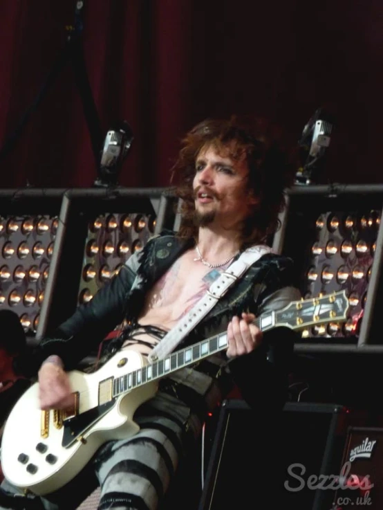 a man is holding his guitar up to the crowd