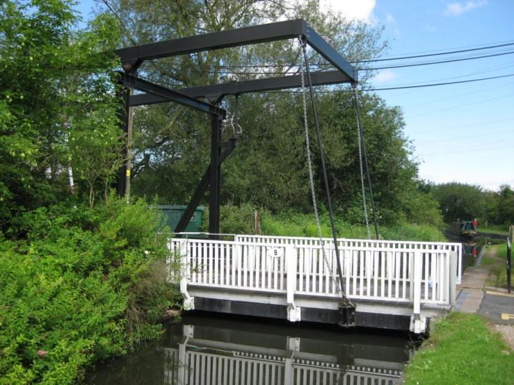 white bridge with metal frame over running creek