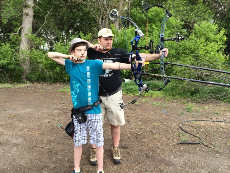 a man and  holding a big bow and a compoundagle