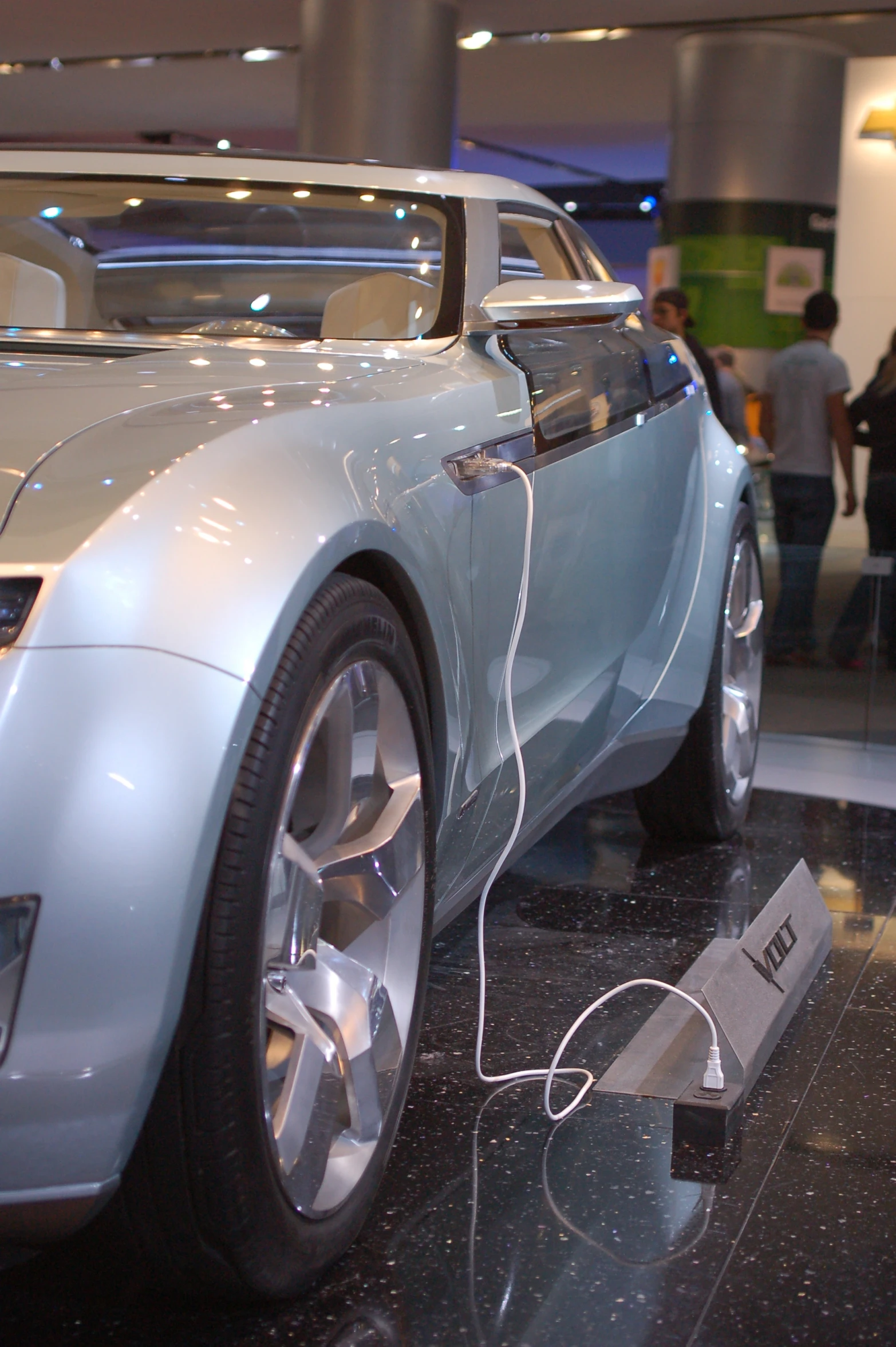 a futuristic looking car on display with a white remote