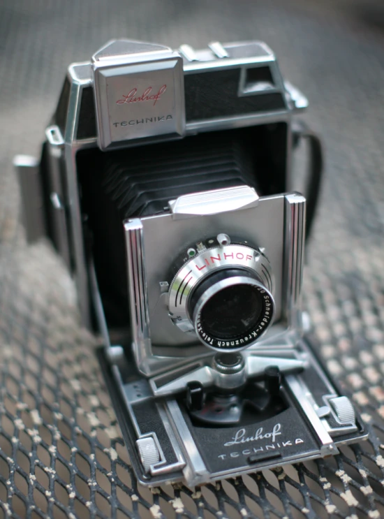 an old fashion movie camera sitting on a mat