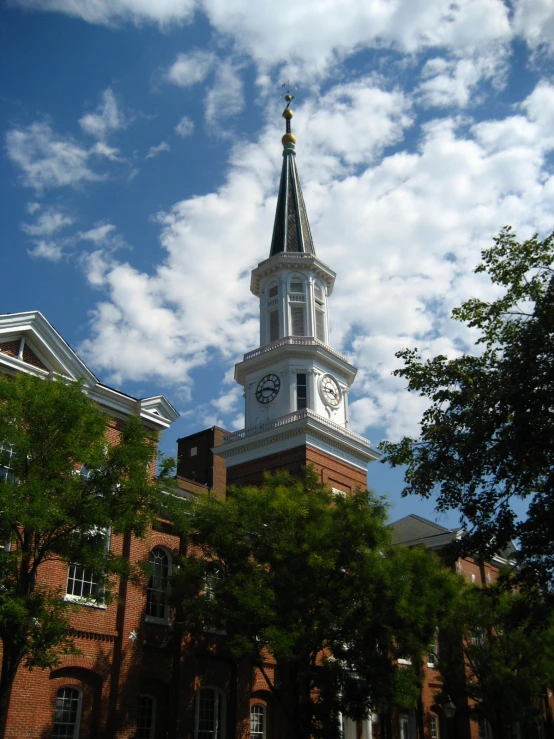 a white clock tower stands in the sunlight