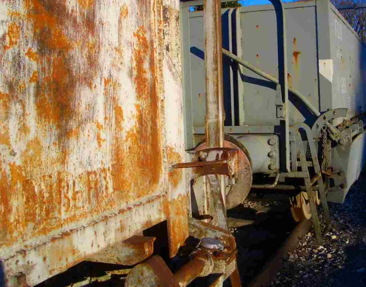 a rusted train car sitting near another abandoned train