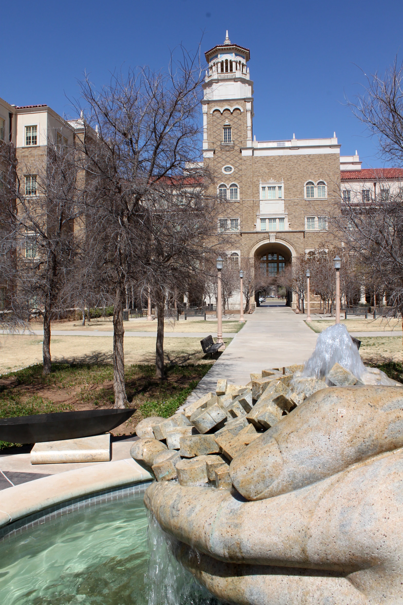 a fountain in a park with buildings in the background