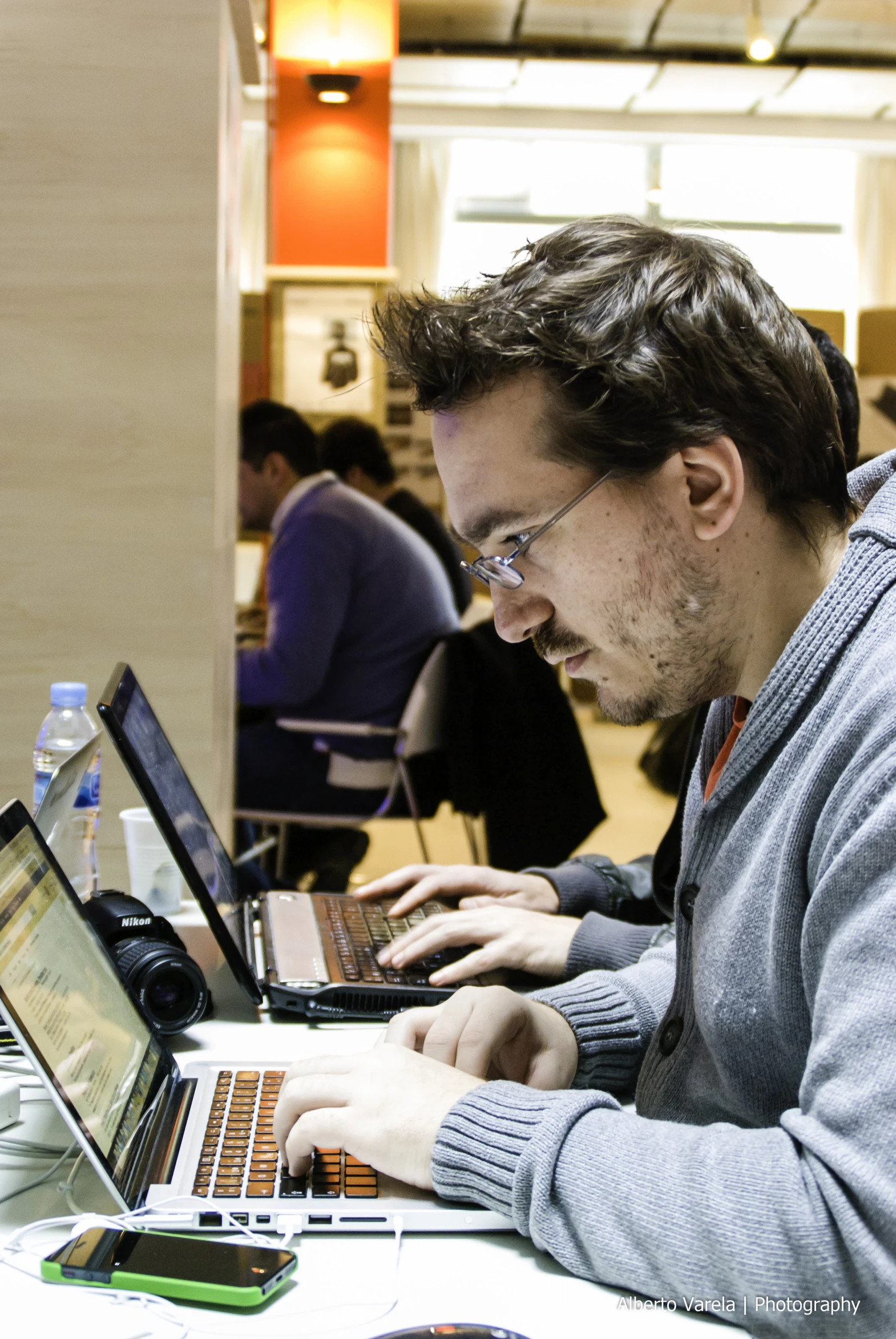 man sitting in a chair typing on his laptop