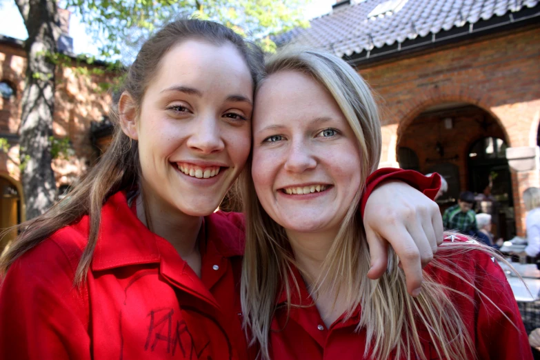 two girls wearing red shirts posing for a po