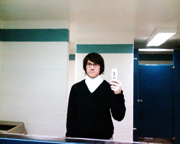 a man is taking a selfie in the bathroom mirror