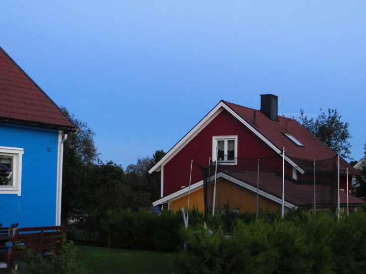 a house next to a blue one with white windows