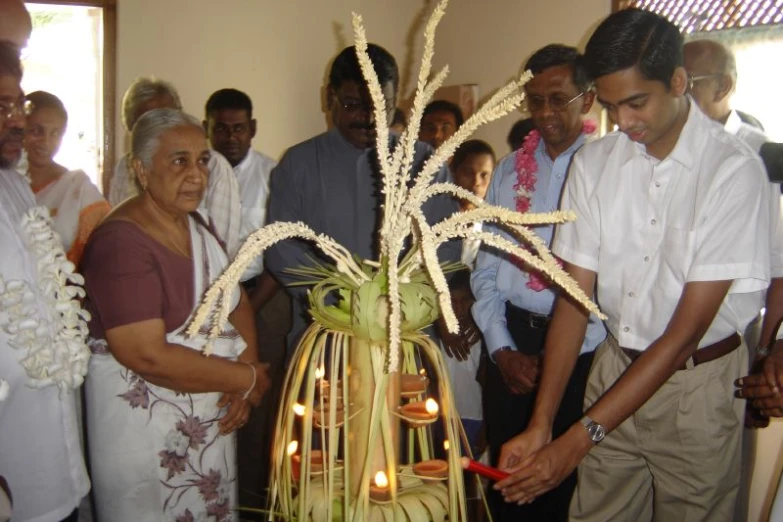 people standing around a table with a decorative arrangement