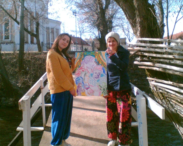 two women posing for a picture on a bridge