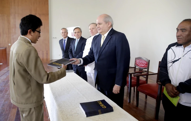 a man is receiving a priest's book during his presentation