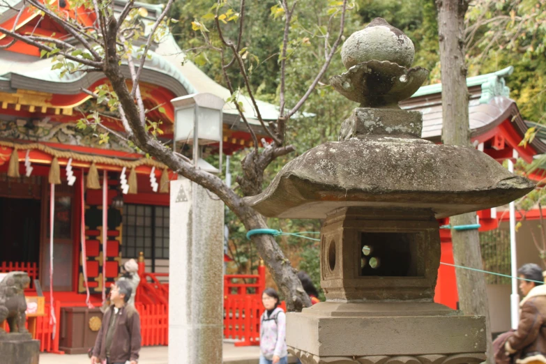 people are outside a chinese temple with decorations on the tree