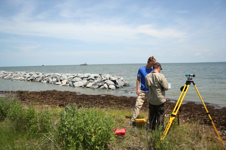 the two men are taking pictures while looking into the water