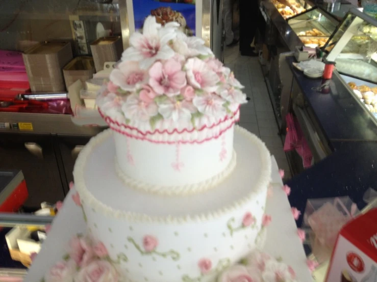 two tiered wedding cake with flowers on display