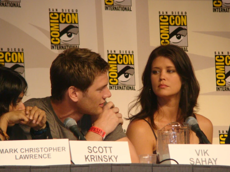 the two actors are sitting in front of the microphone