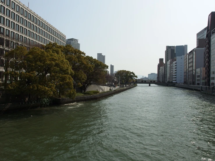 the river is running through the city on a sunny day