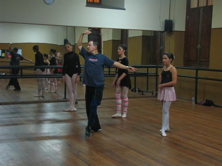 a man is standing in a dance studio talking on a phone