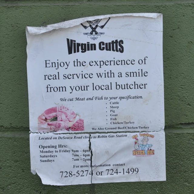 the sign is by a wall that reads virgin cuts