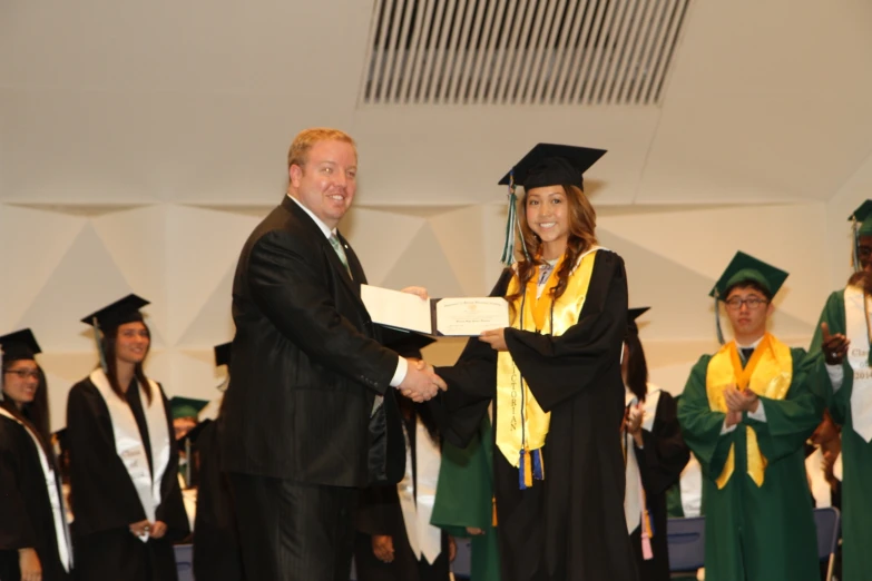 a person is holding a certificate with people in the background