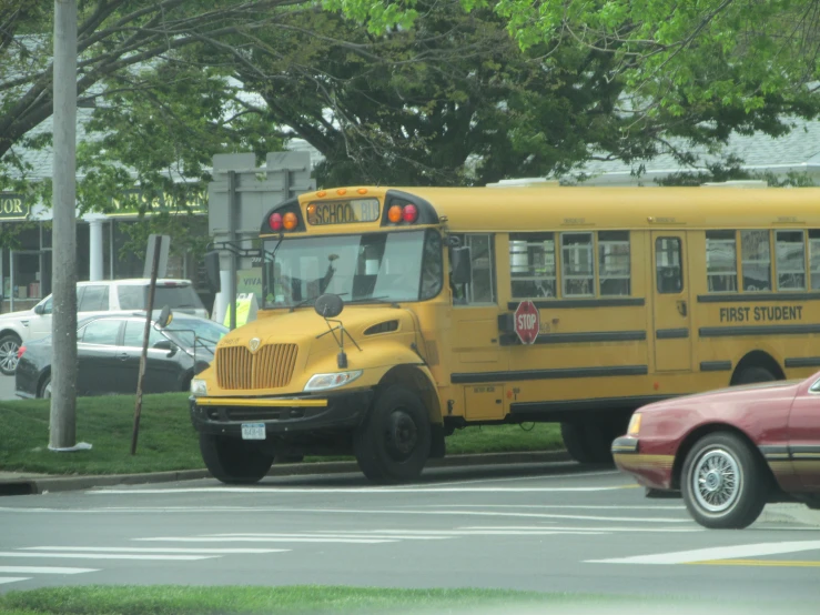 two school buses at an intersection on the street