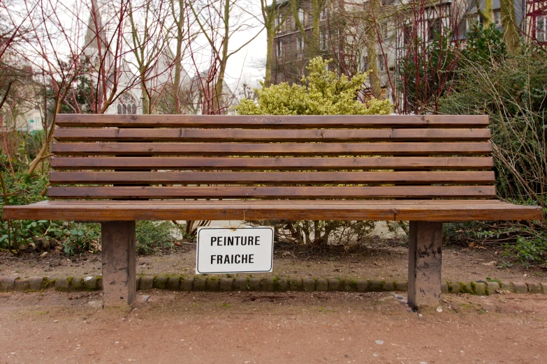 a bench with an for rent sign sitting under the wooden frame