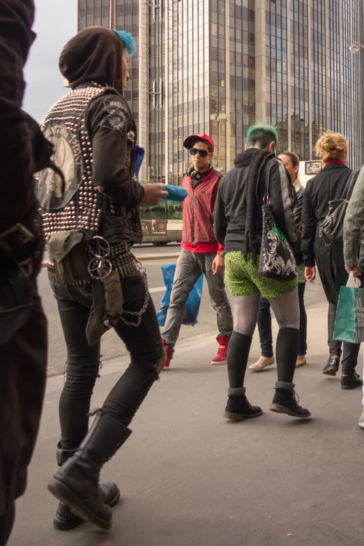 people standing in front of a building one man in an odd costume pointing towards another woman with a weird look