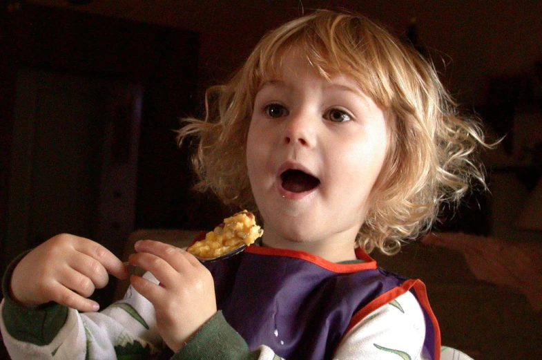 the little boy is enjoying eating some food