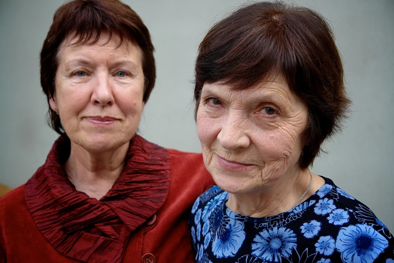 two women with short hair standing together smiling