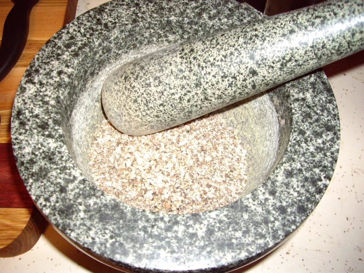 a bowl with a wooden handle and a black brush