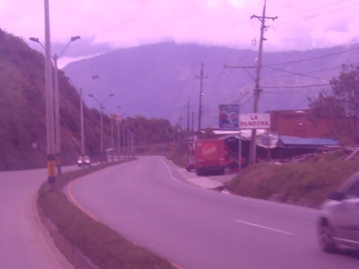 a car drives down a winding road near houses