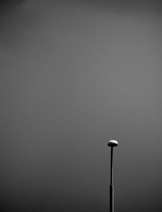 a street light on an empty street next to a light pole