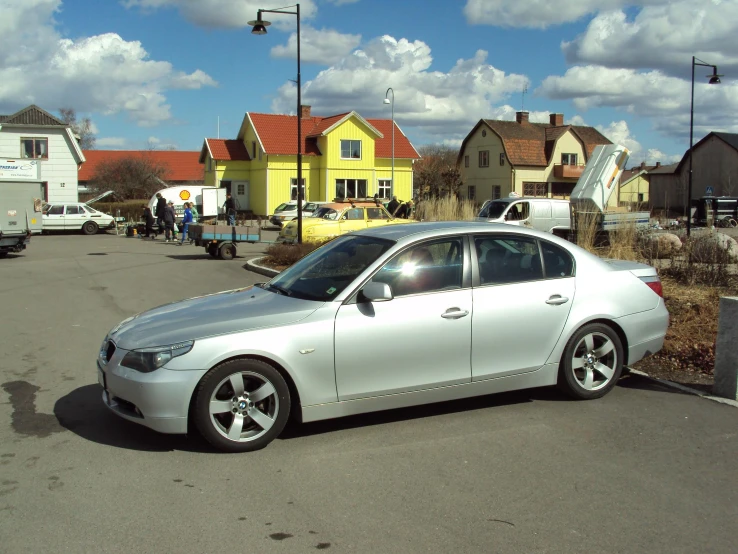 a white bmw parked in the parking lot in a residential neighborhood