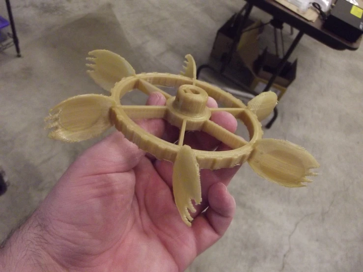 a hand holding an item with a ring made of pasta