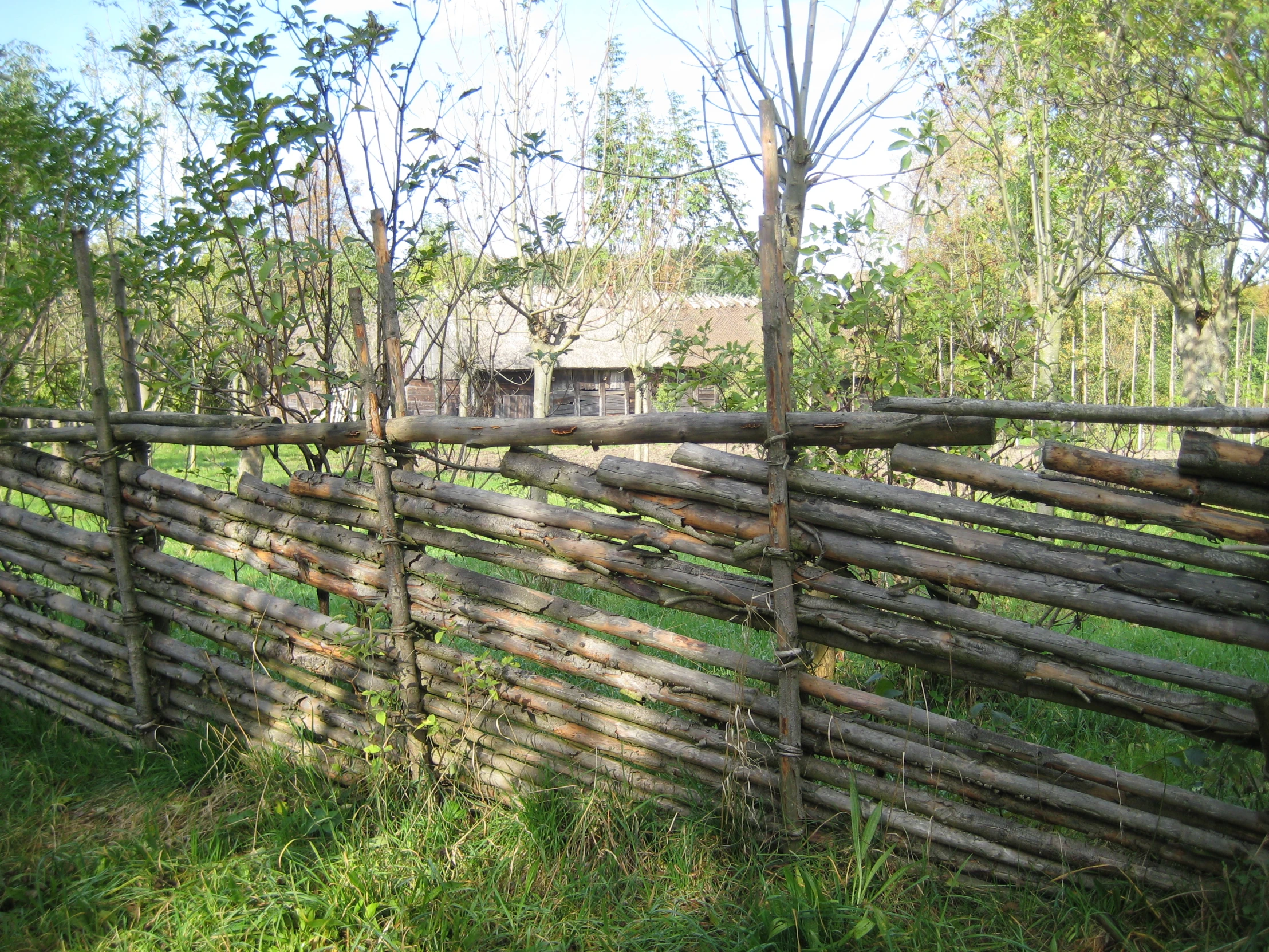 a fence made of wood and boards along a road