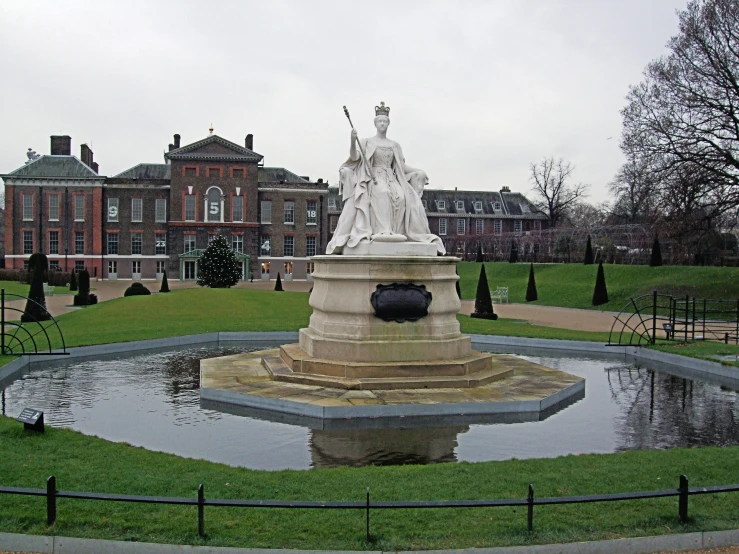 a statue is in the middle of a small pond