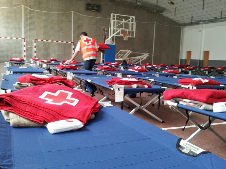 a room with rows of folding tables topped with towels