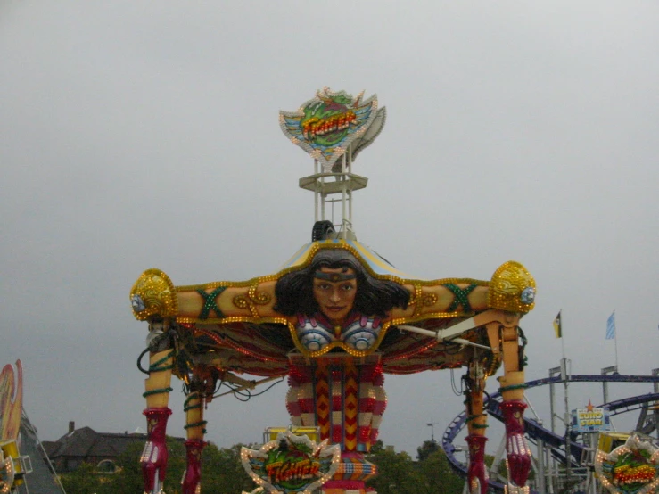 a parade float features a statue wearing a mask and dress